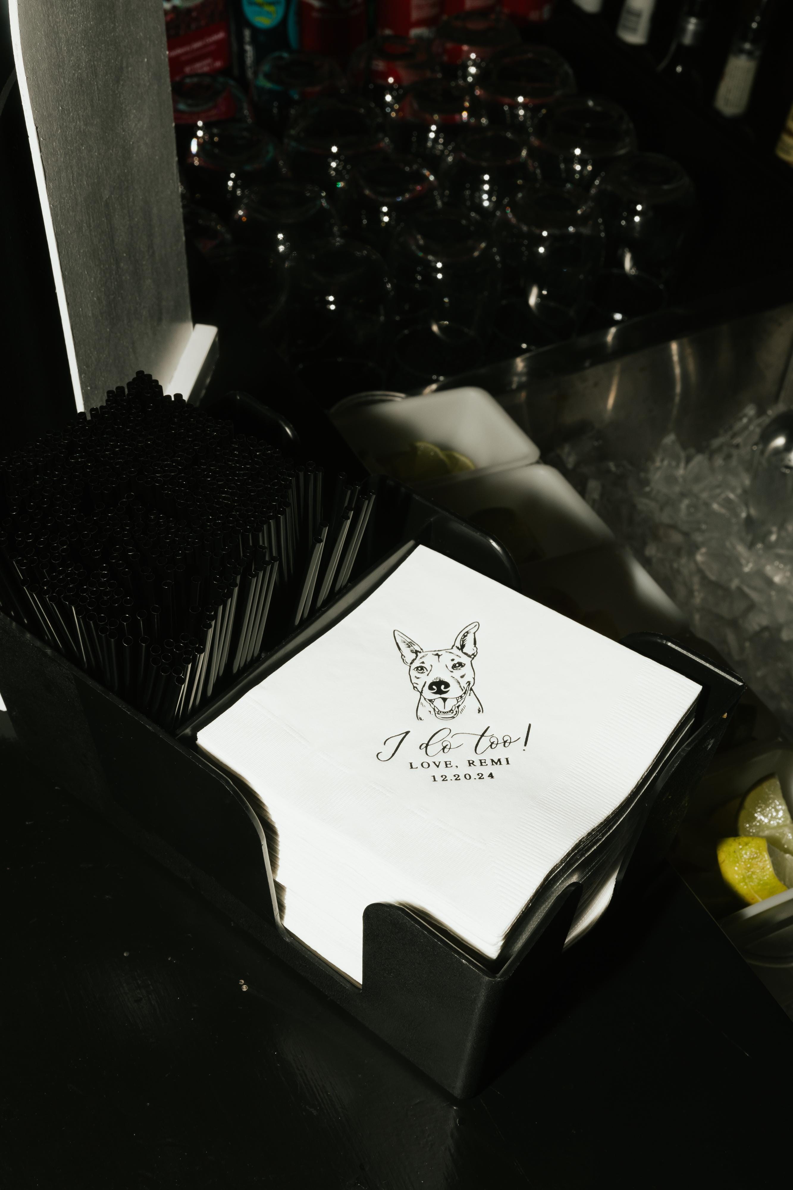 Elegant white paper cocktail napkins featuring a custom pet illustration, perfectly arranged for a celebratory bar service.