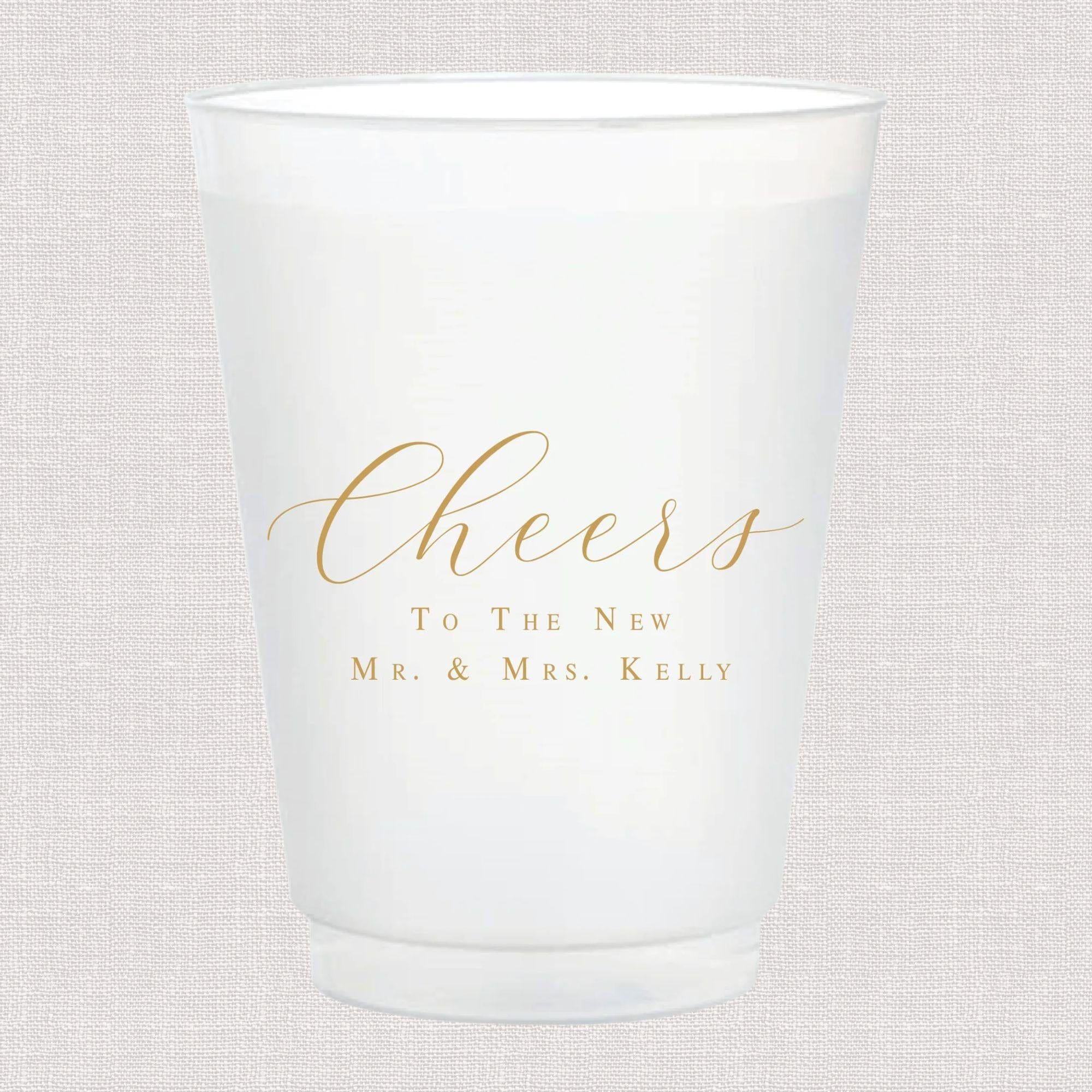 Frosted white cup with gold "Cheers" text and "To The New Mr. & Mrs. Kelly" personalization
