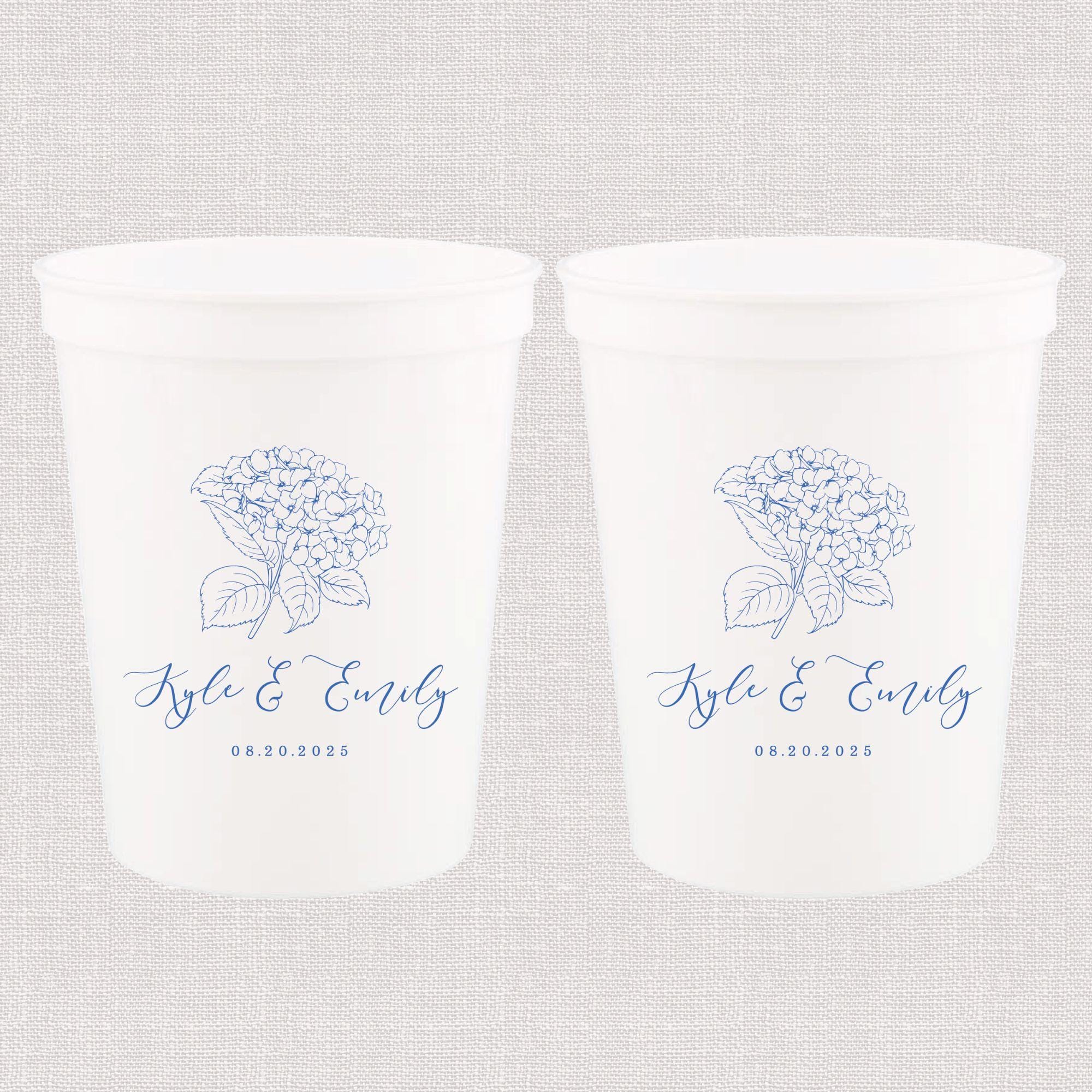 Two white stadium cups with blue hydrangea flower and personalized names "Kyle & Emily" printed on front