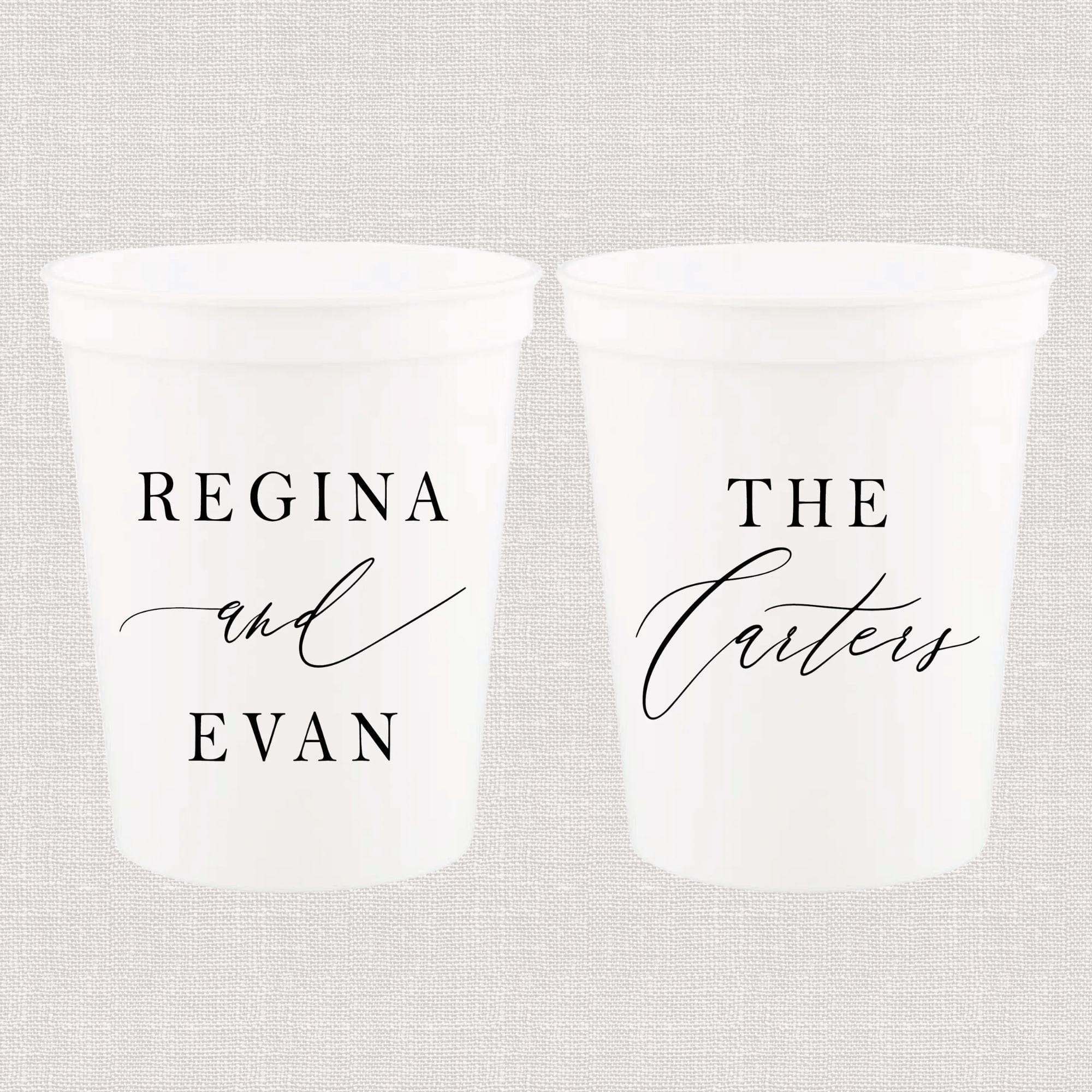 Two white frosted stadium cups with black personalized text reading "Regina and Evan" on one cup and "The Careys" on the other