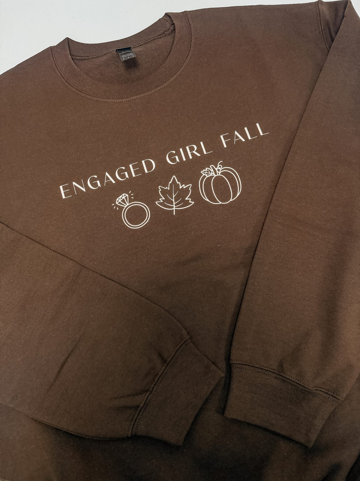 Flat lay of brown Engaged Girl Fall sweatshirt, fall engagement apparel for the newly engaged