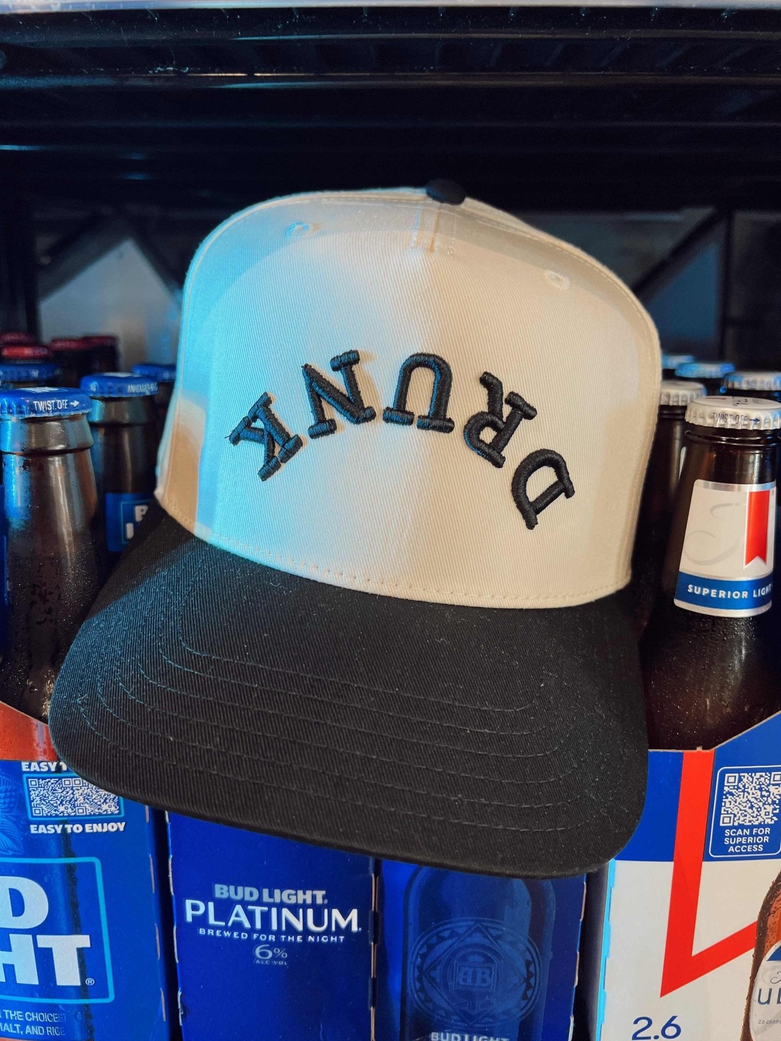 White and black colorblock trucker hat with "DRUNK" text across the front panel