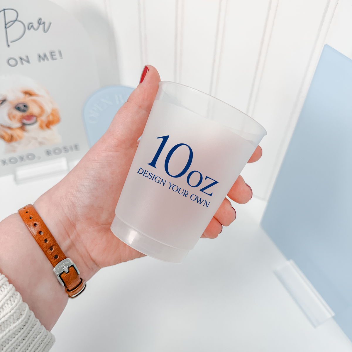 Hand holding a 10 oz frosted shatterproof cup with a custom navy design for weddings