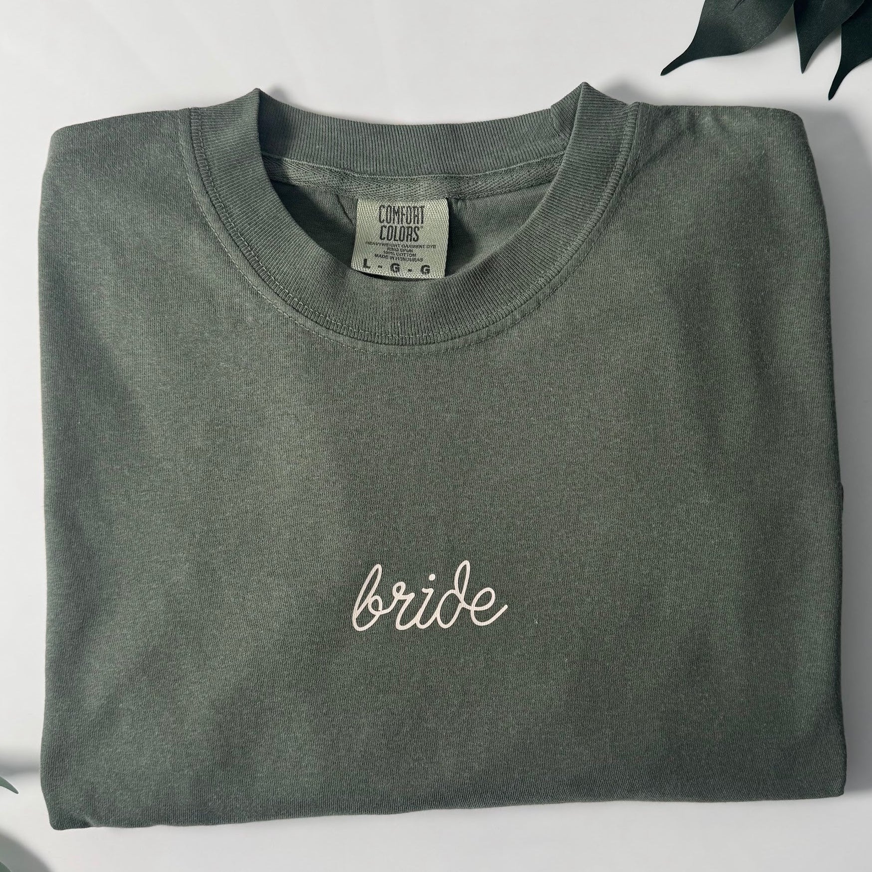 Hunter green Comfort Colors 1717 embroidered bride t-shirt with white script Bride embroidery, front view