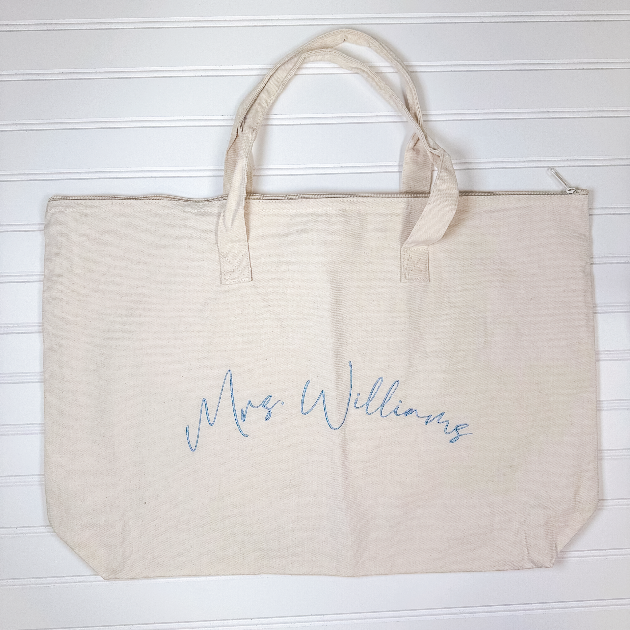Large natural canvas tote with zip-top closure and canvas handles