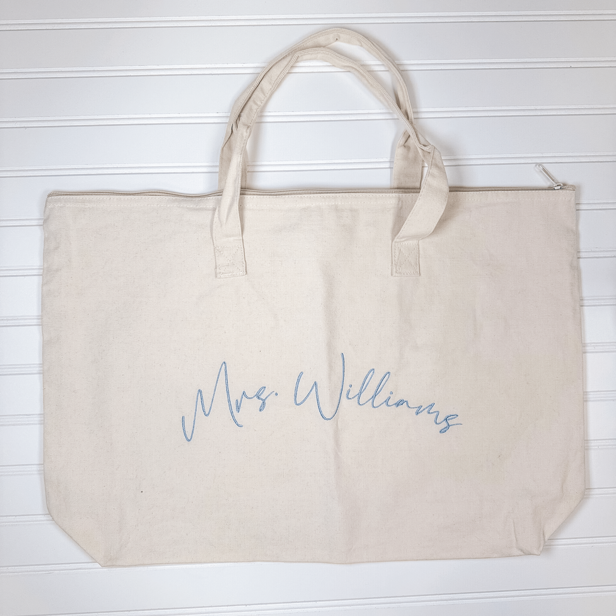 Large natural canvas tote with zip-top closure and canvas handles