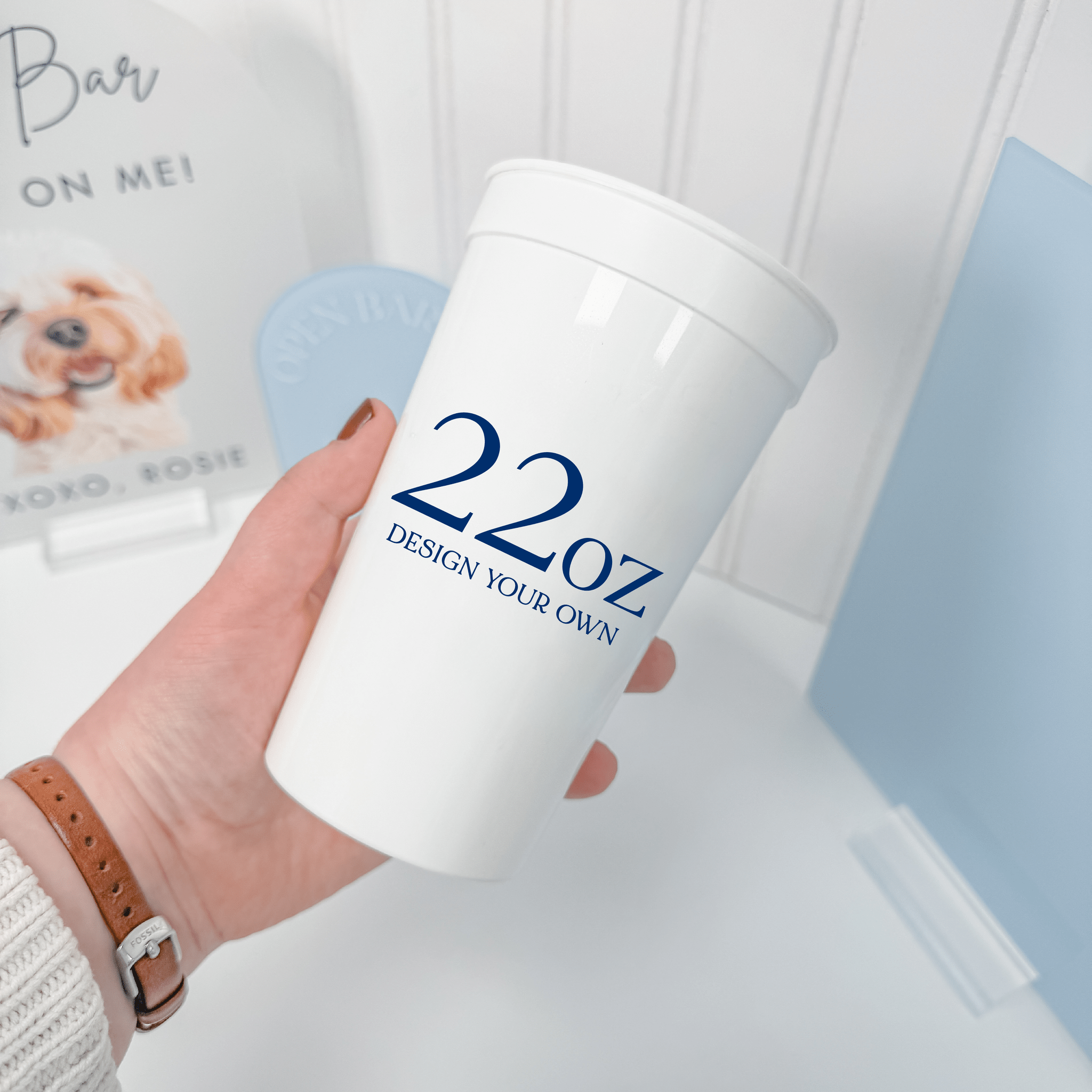 22 oz white stadium cup held in hand, reusable party cup with a custom navy design
