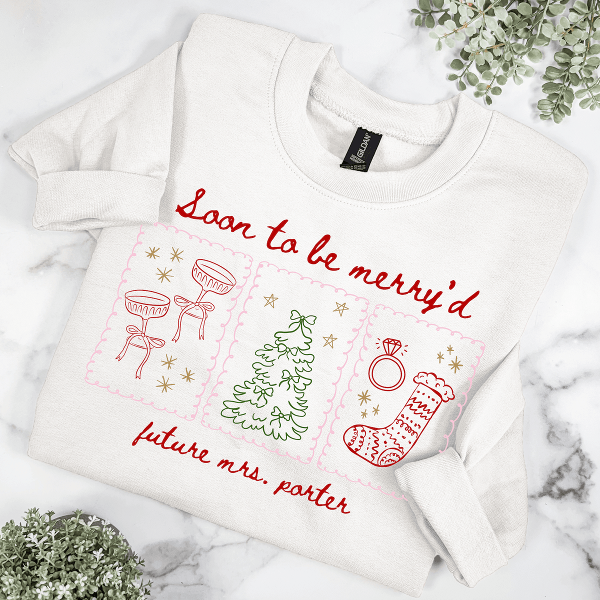 Personalized Soon to Be Merry'd Christmas bride sweatshirt featuring festive champagne glasses, Christmas tree, engagement ring, and custom future last name.