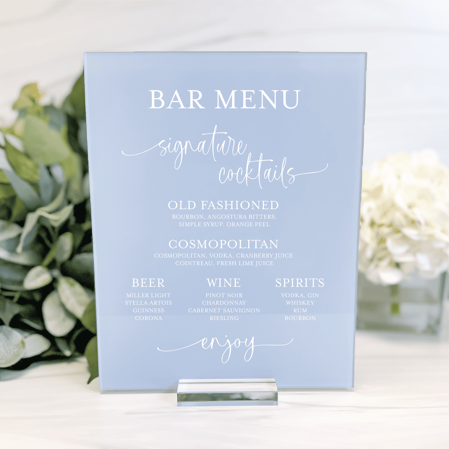 Light blue acrylic bar menu sign with white script and serif text listing signature cocktails, beer, wine, and spirits options for a wedding reception.