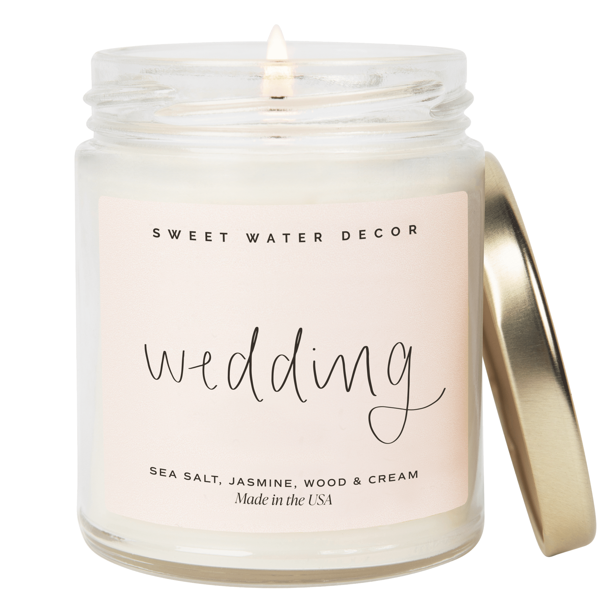 Clear glass jar candle with gold lid labeled "wedding" by Sweet Water Decor, sea salt jasmine scent.