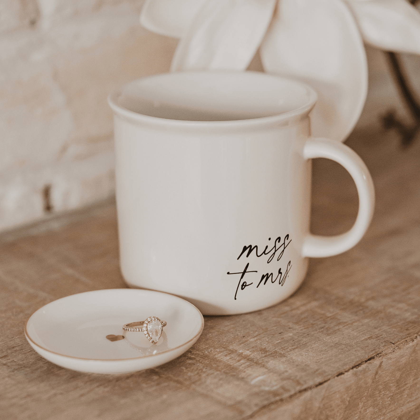 White ceramic mug with "miss to mrs" handwritten script and matching coaster with ring design