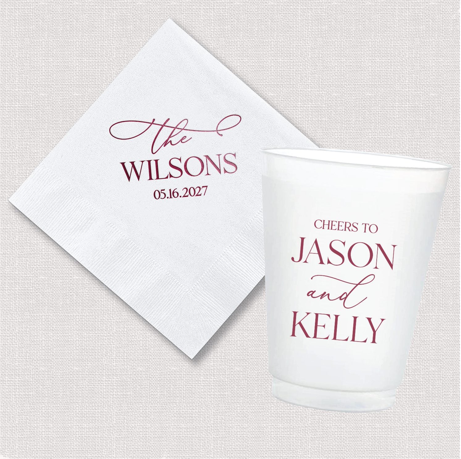 The Elegant Last Name personalized cocktail napkin and frosted shatterproof cup bundle with bold serif last name and script design in deep berry