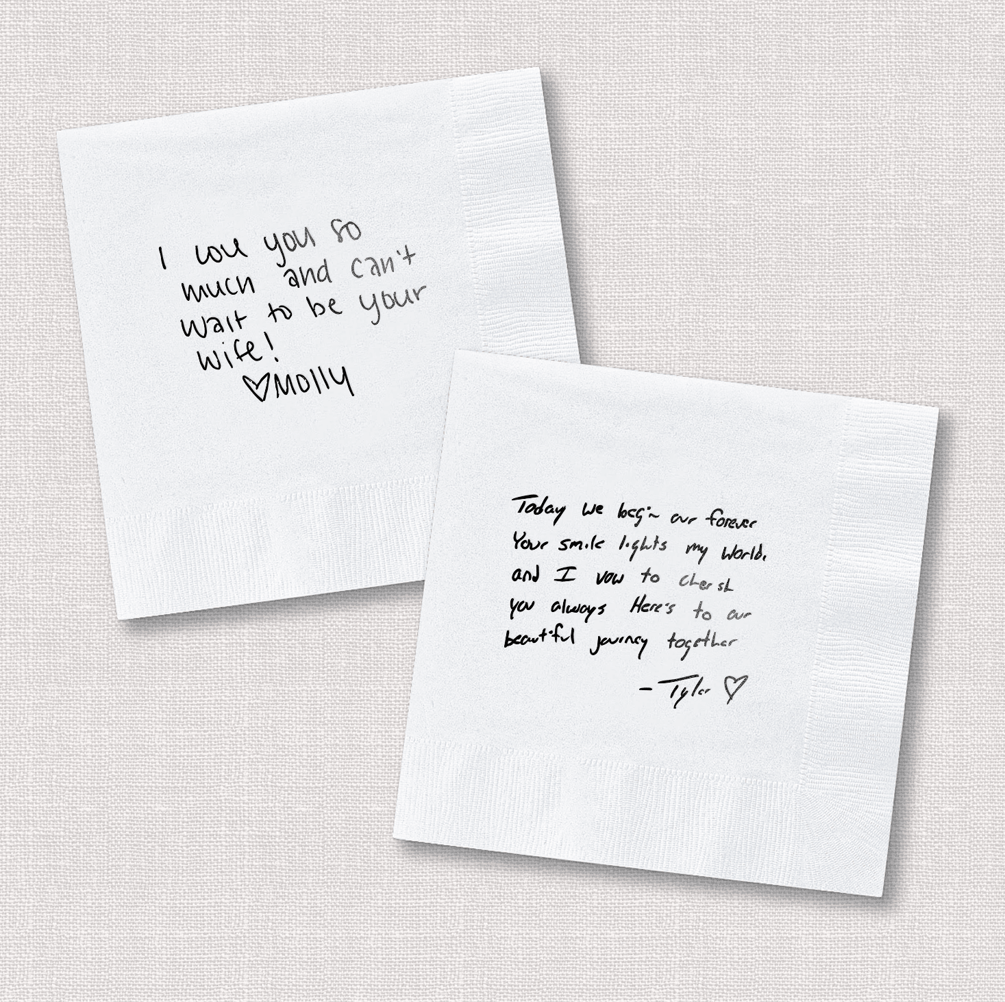 Two white napkins with handwritten messages in black ink, including romantic sentiments and signatures, displayed at an angle.