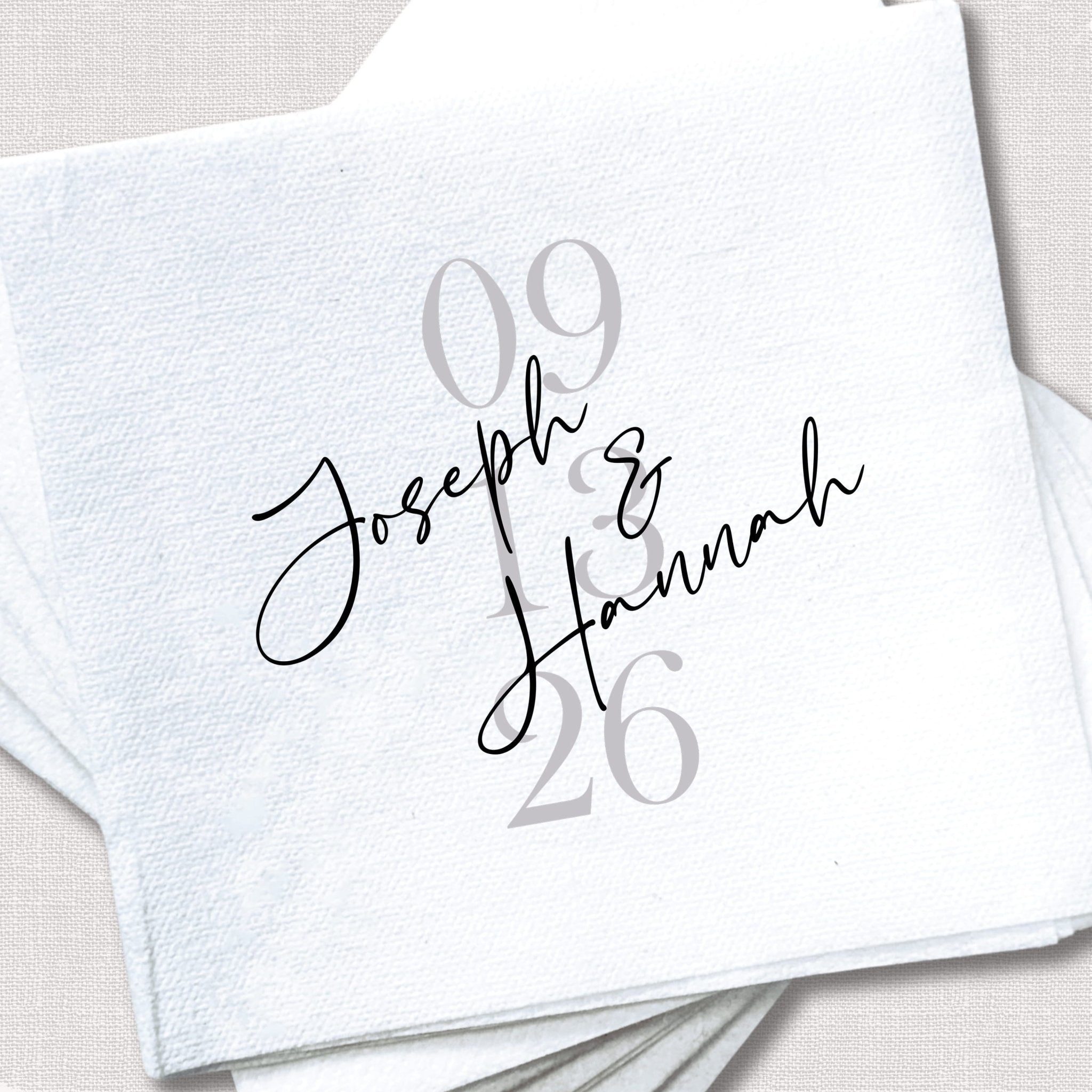 White napkin printed with "09.26" in gray and personalized names "Joseph & Hannah" in script font