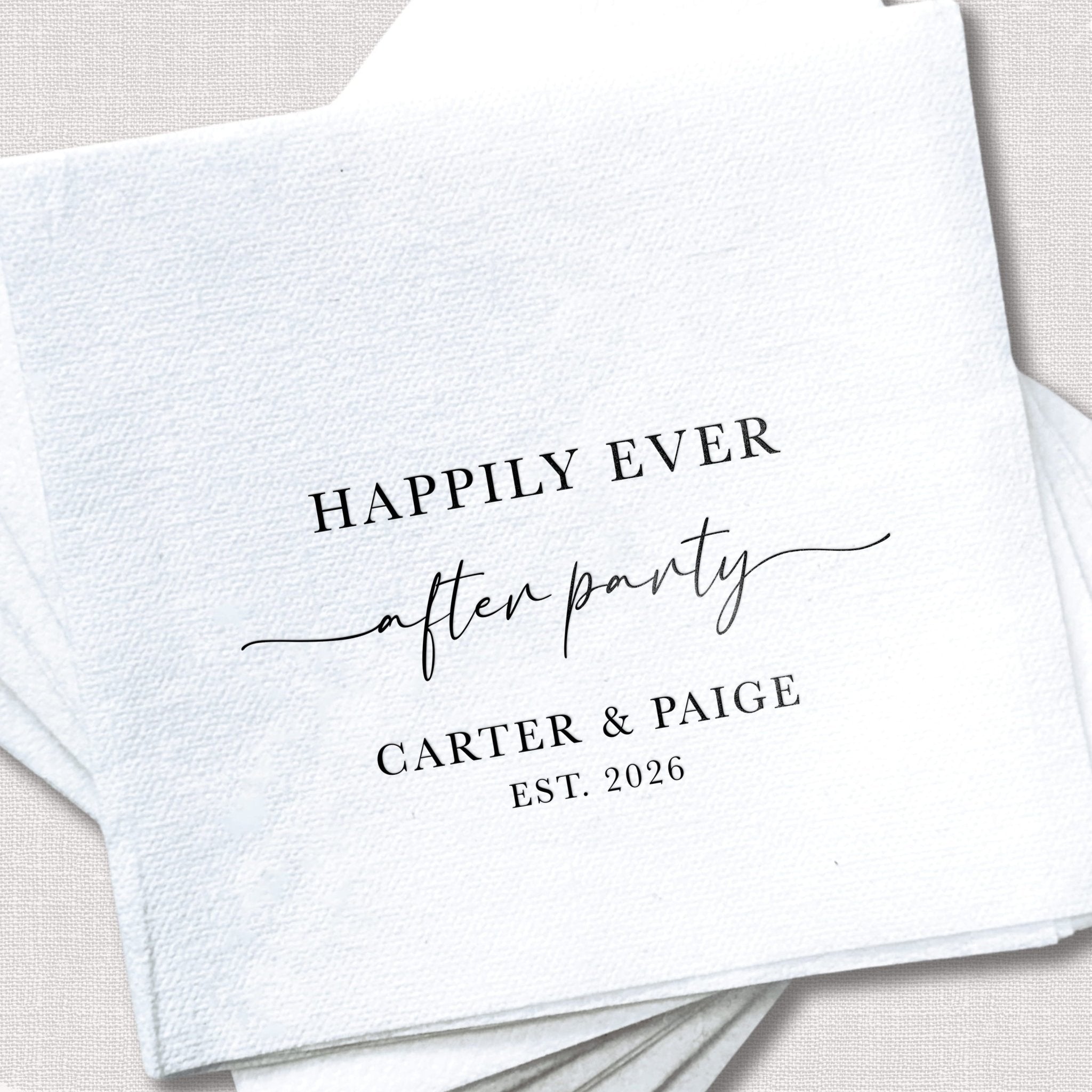 White linen napkin with black foil-stamped text reading "Happily Ever After" and "after party" with personalized names "Carter & Paige" and "Est. 2026" below.