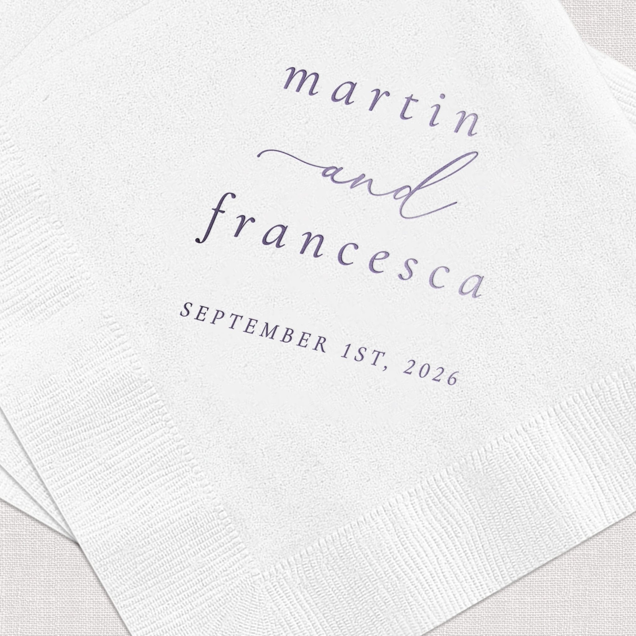 White cocktail napkin with gray foil stamped text reading "marrin and francesca" with wedding date "september 1st, 2026"