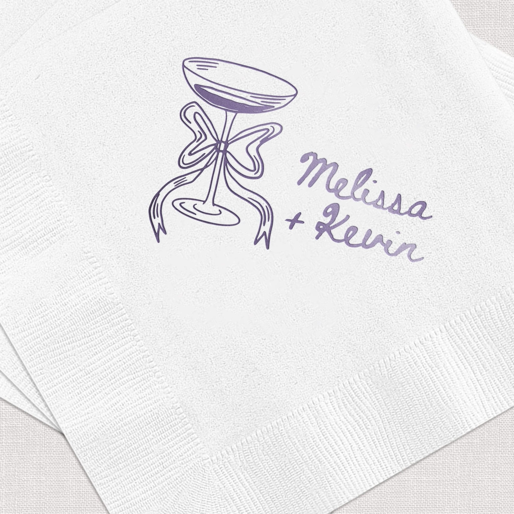White napkins with purple hourglass design and "Melissa + Kevin" personalization text