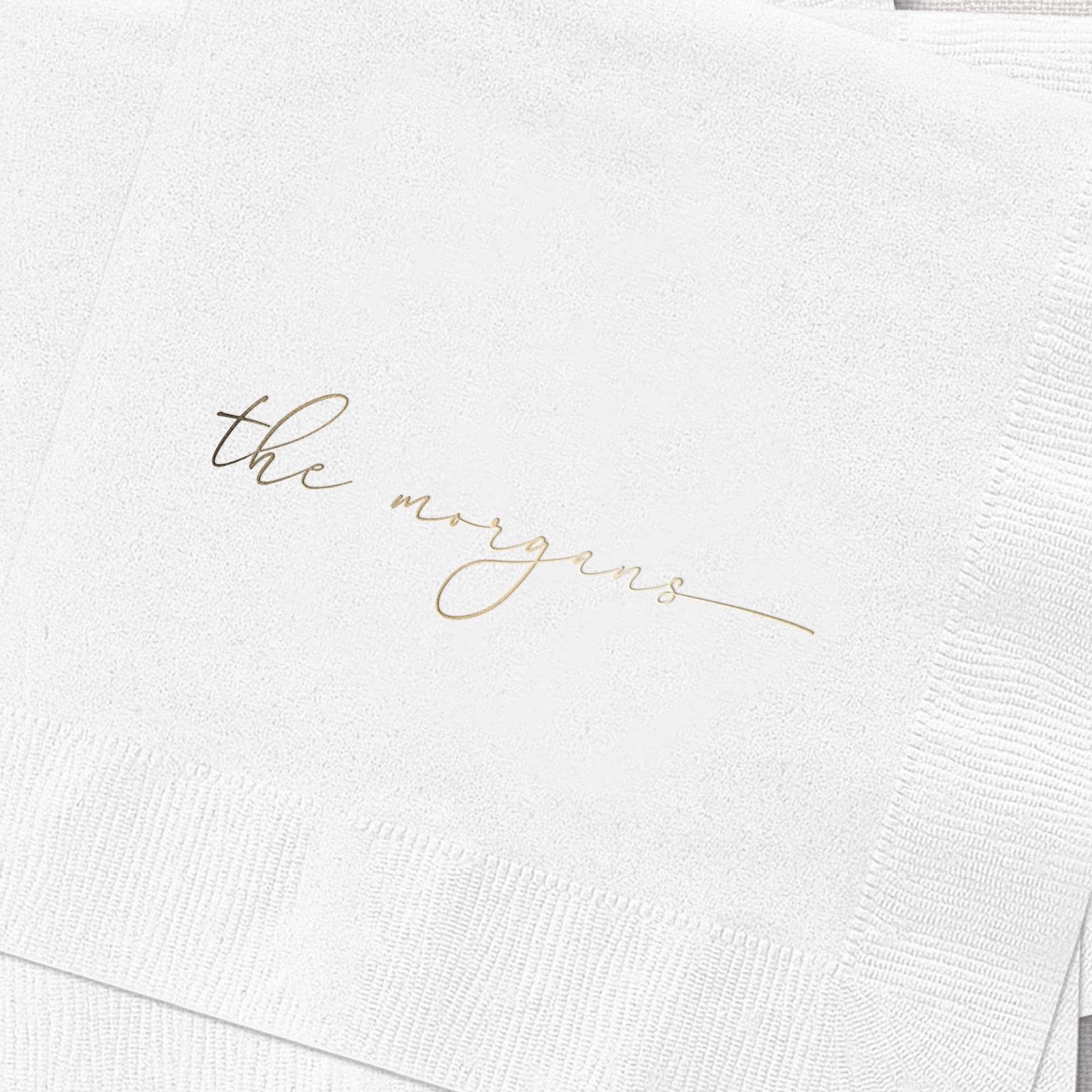 White cocktail napkins with gold foil stamped text reading "the newlyweds"