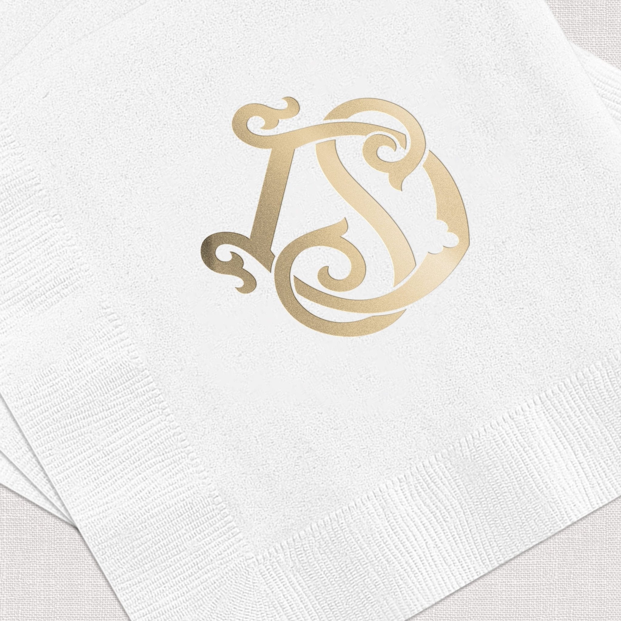 White napkin with gold foil stamped monogram featuring ornate letters D and S design