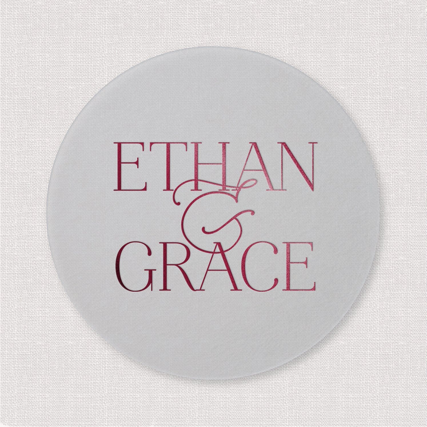 White circular coaster with burgundy text reading "ETHAN & GRACE" and decorative ampersand design