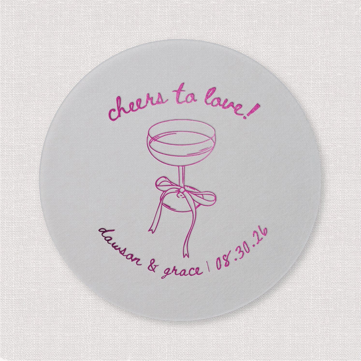 White coaster with pink hand-drawn cocktail glass and "cheers to love!" text, personalized with names and wedding date