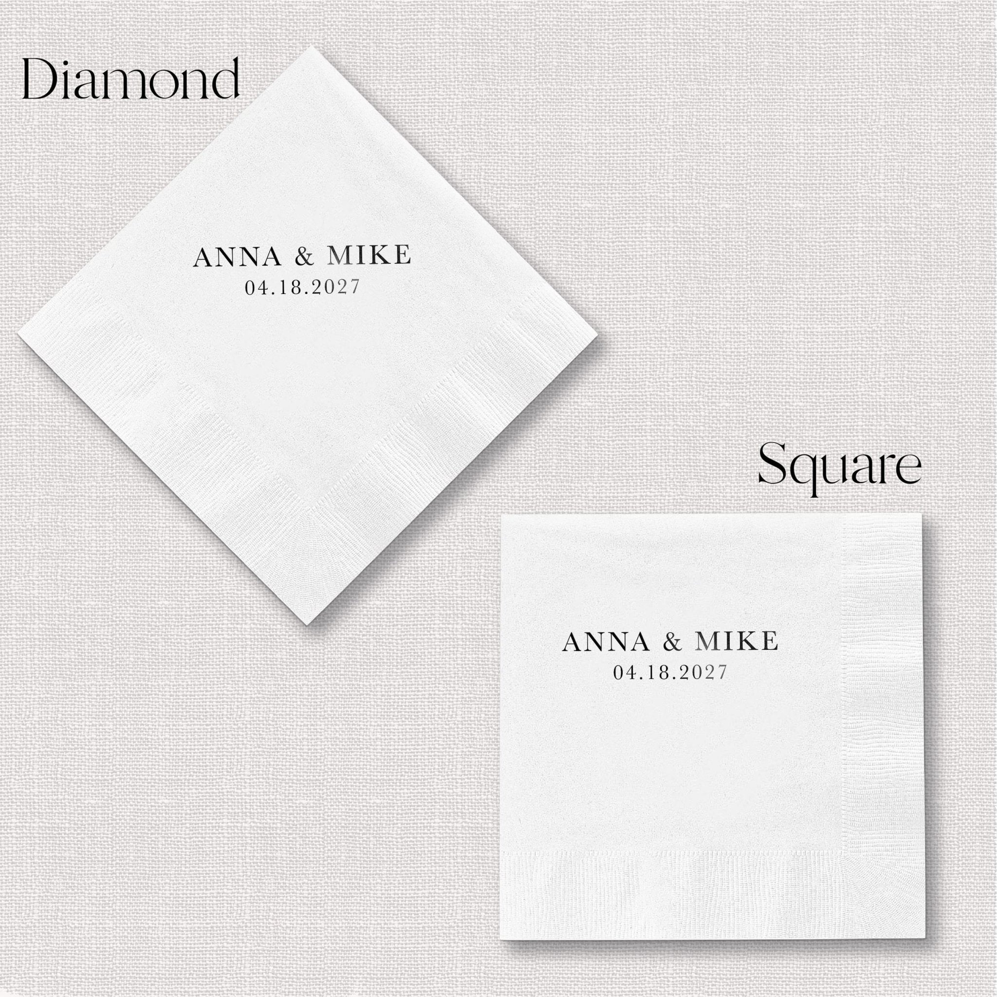 White foil-stamped cocktail napkins in diamond and square shapes personalized with "Anna & Mike" and wedding date 04.18.2027.