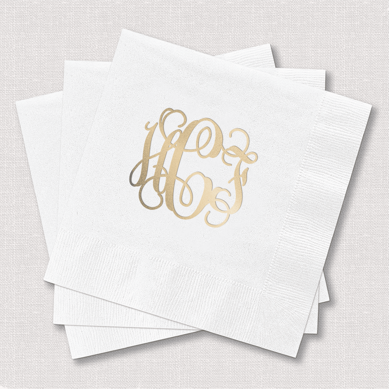 White napkins with gold foil monogram initials in script design