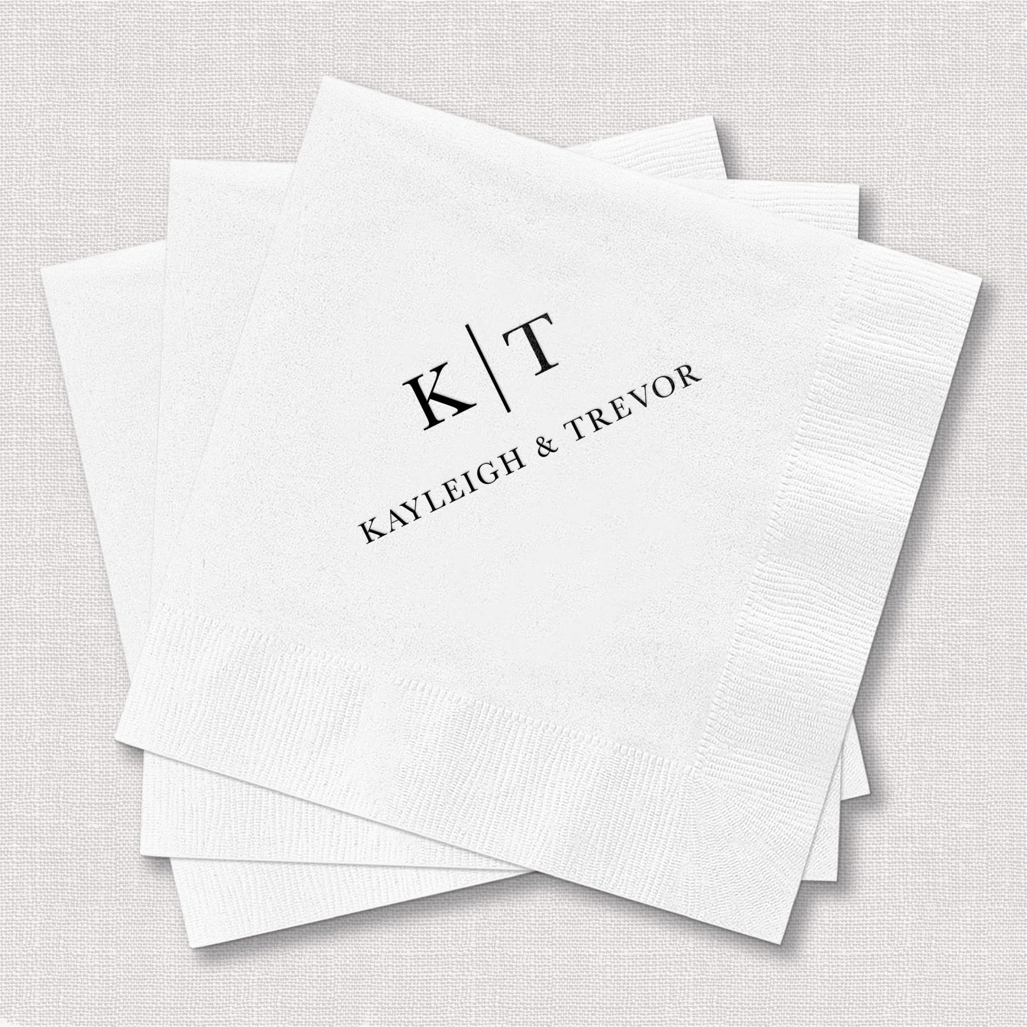 White foil-stamped napkins personalized with initials K T and names Kayleigh Trevor in elegant serif font