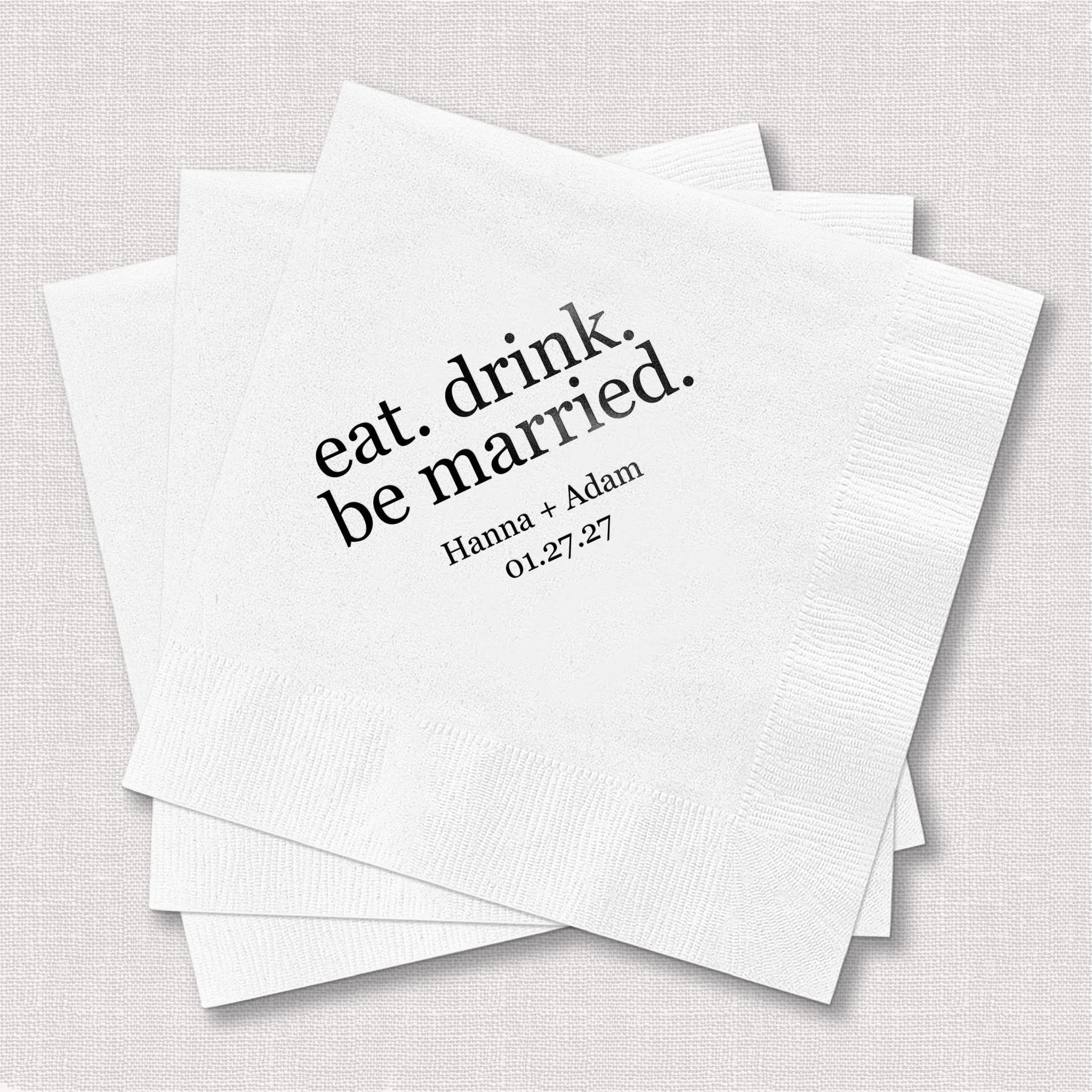 Stack of white napkins with "eat. drink. be married." text and personalized names and date printed in black ink.