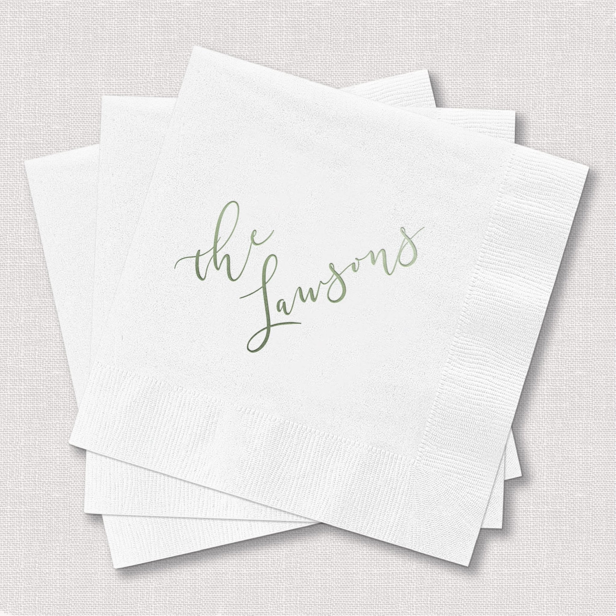 Stack of white napkins with "the lawsons" in gold script lettering