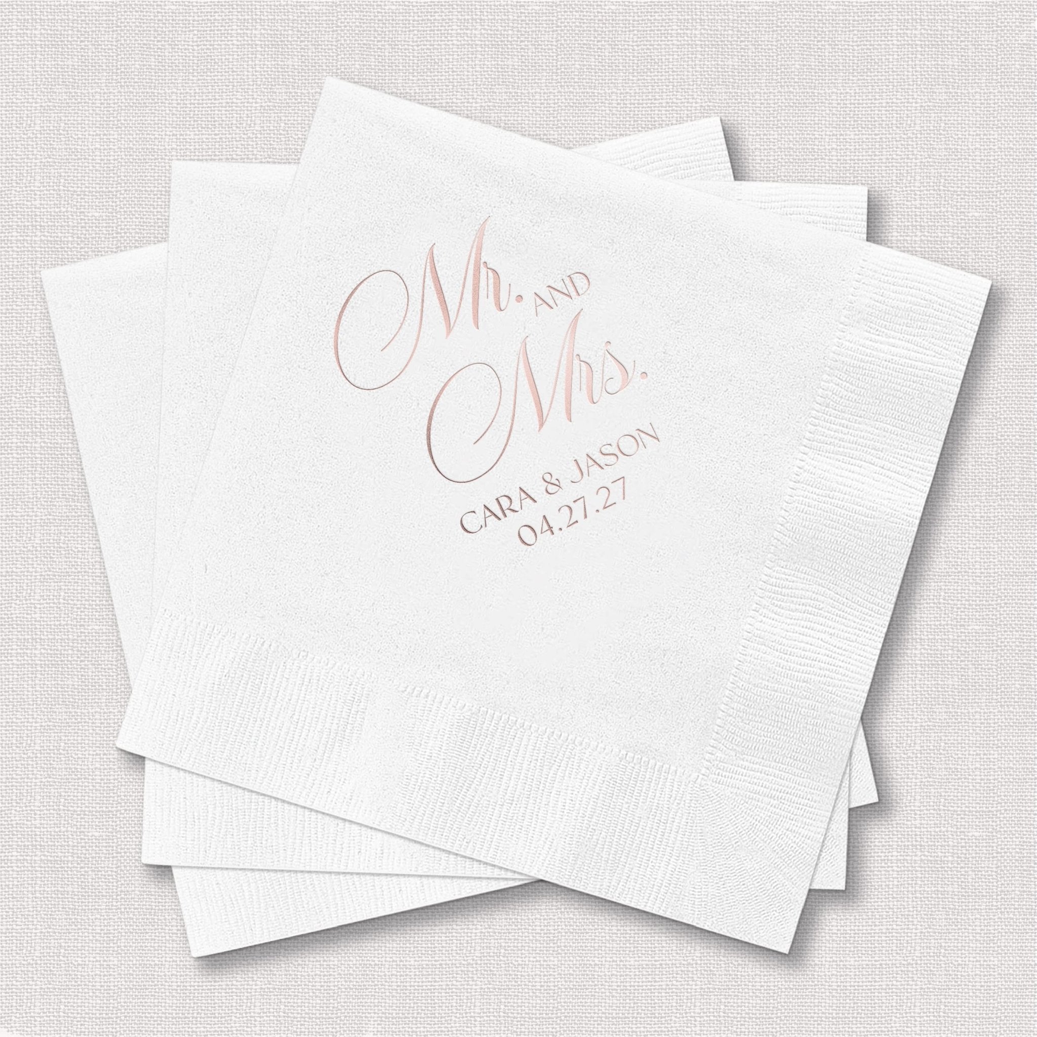 Stack of white napkins with "Mr. and Mrs." in pink lettering and couple's names and wedding date in gray text below