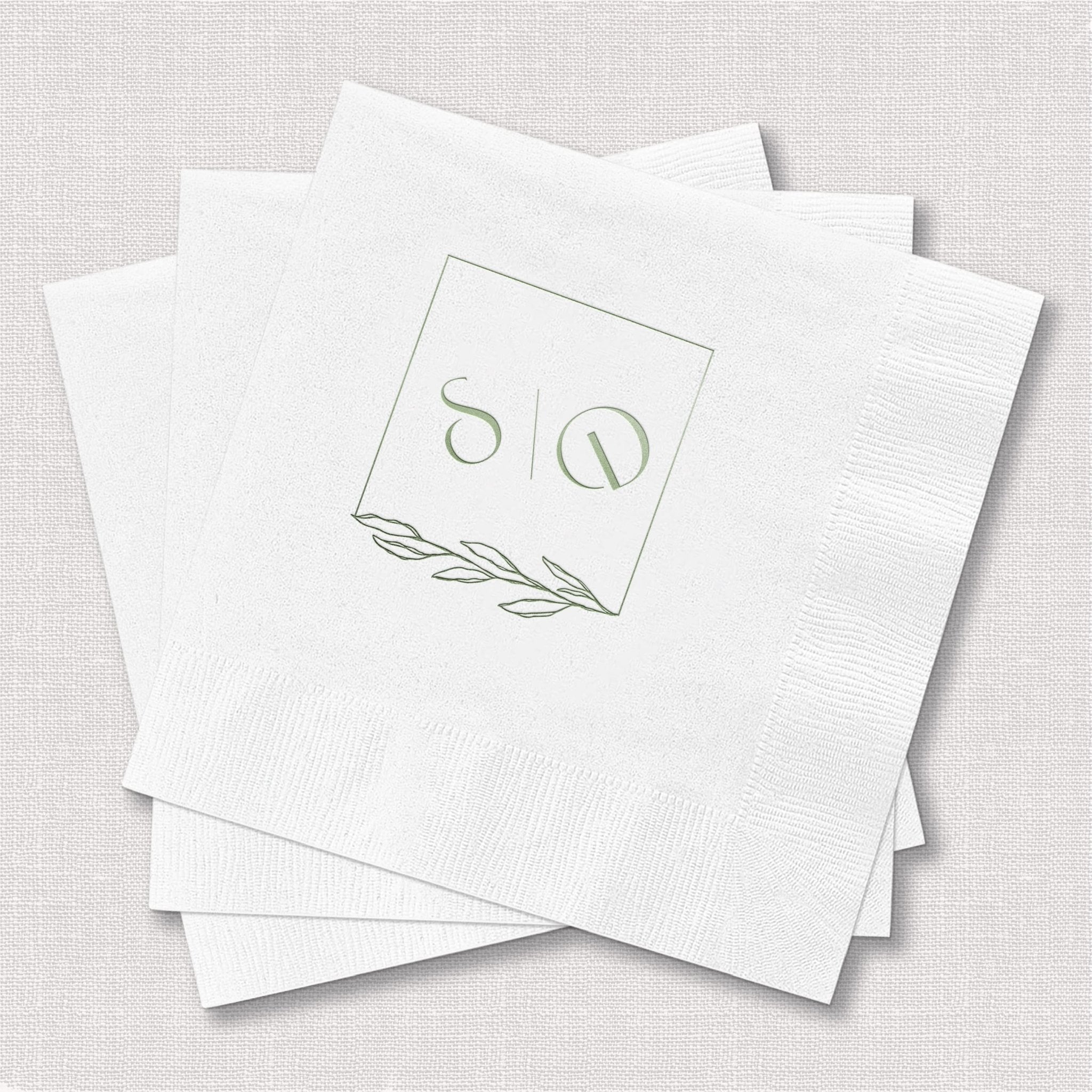 White foil-stamped napkins with two-letter monogram and delicate leaf design in gold foil.