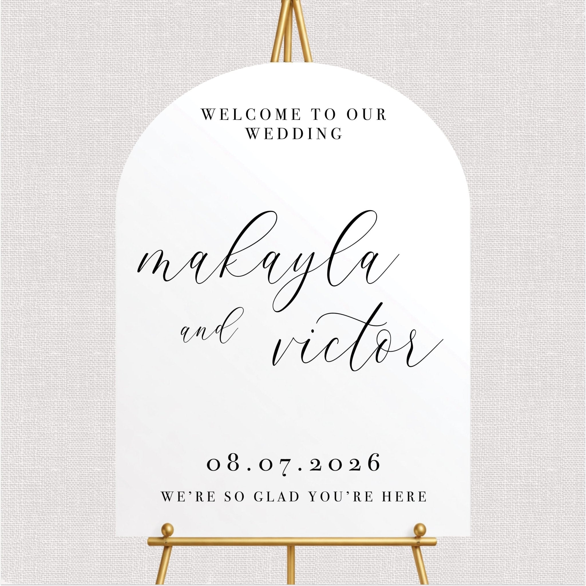White arched wedding welcome sign with script couple text, wedding date, and welcome message in black ink