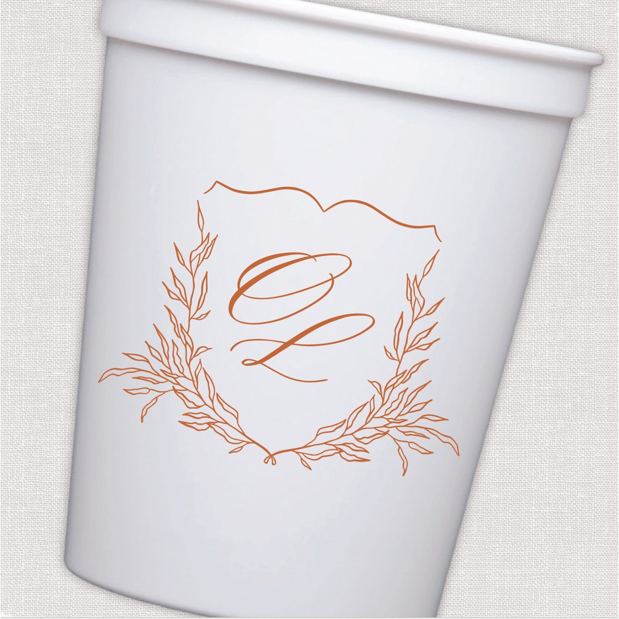 White stadium cup with coral script monogram inside ornate wreath design