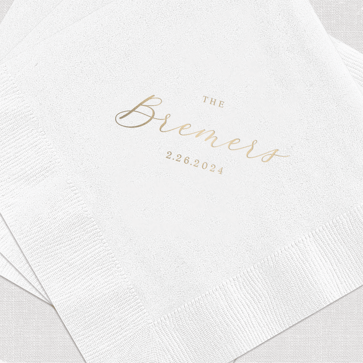White napkins with gold foil stamped text reading "The Blements" and date "2.28.2024"
