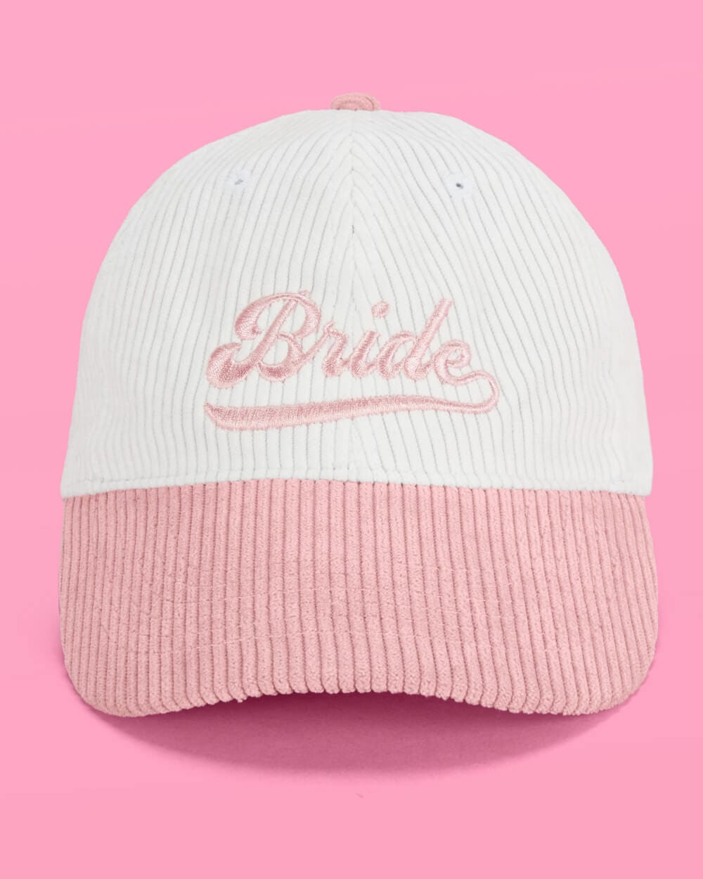 White and pink colorblock corduroy baseball cap with embroidered "Bride" script design on front.