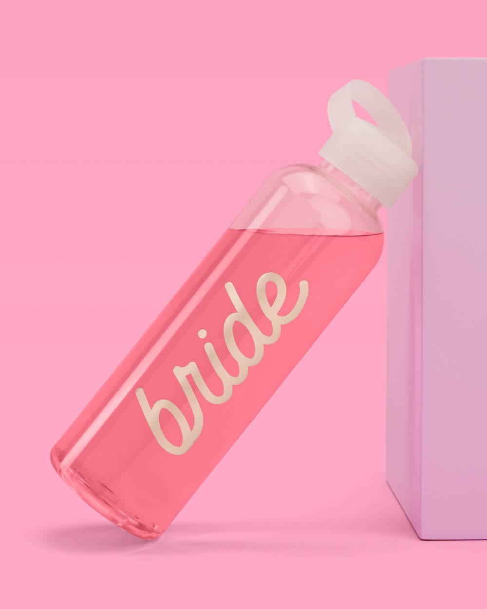 Bright pink water bottle with "bride" text in gold lettering and white flip-top lid against pink background