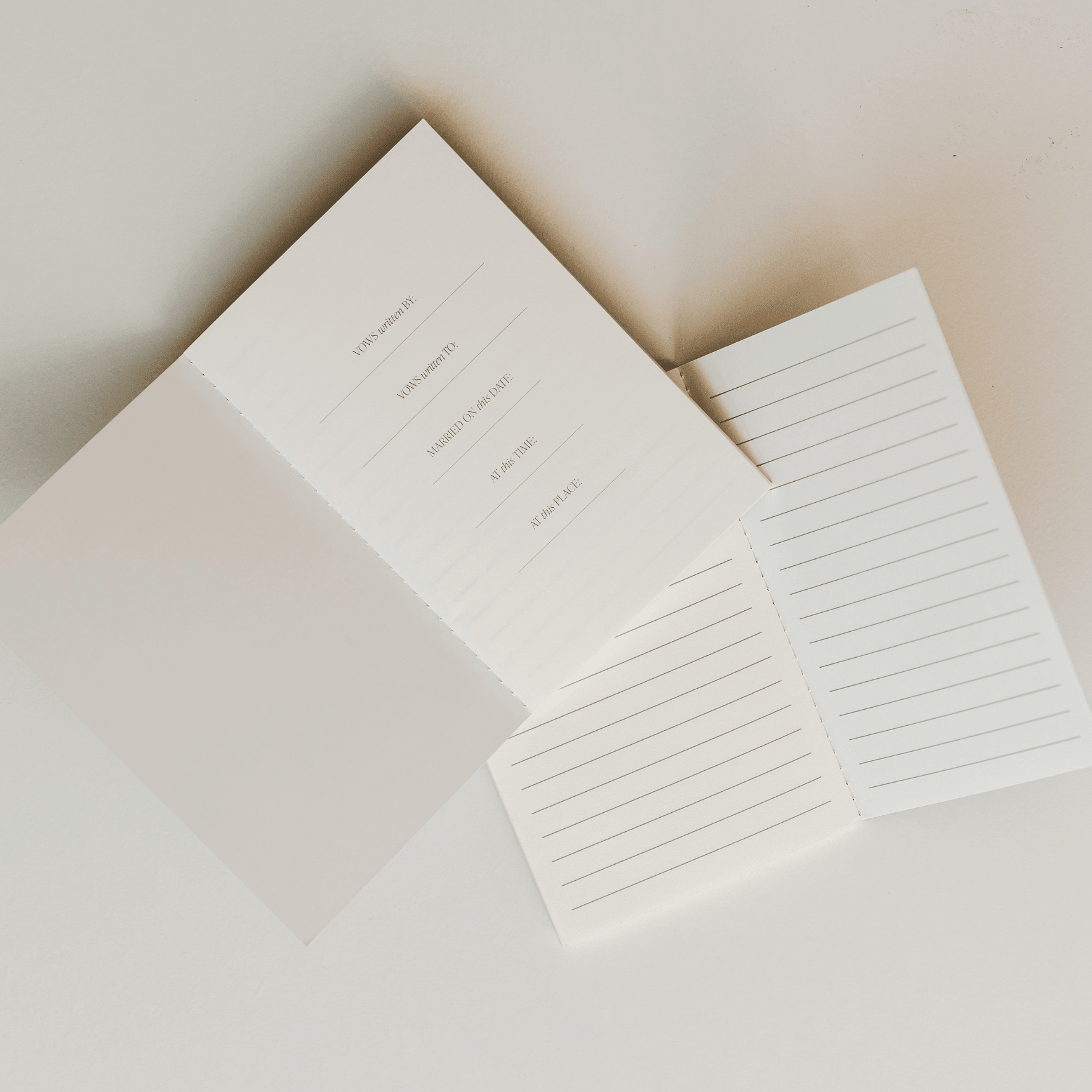 Open white vows journal with lined pages and blank cover, displayed on neutral background.