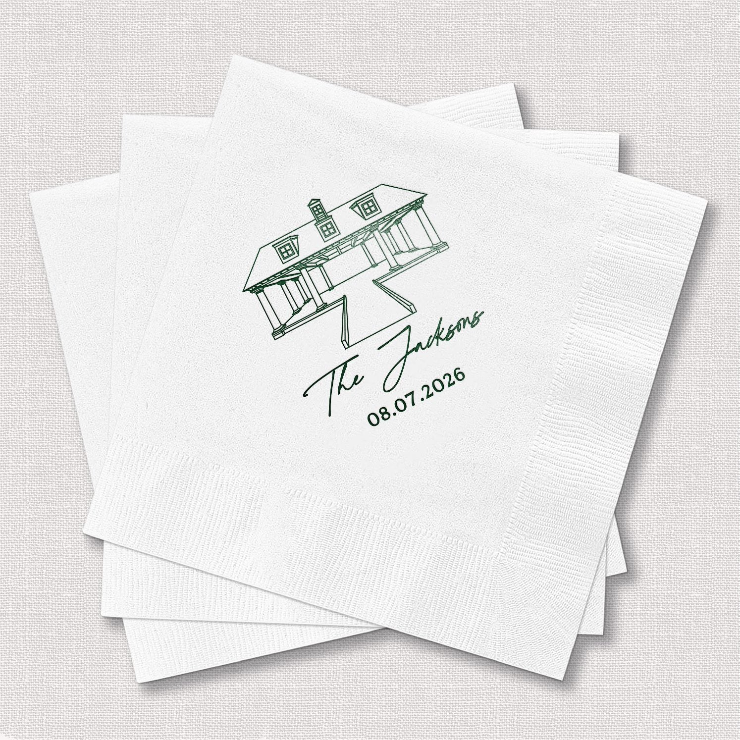 Stack of personalized white cocktail napkins with venue stacked names wedding design printed with couple's names and venue details