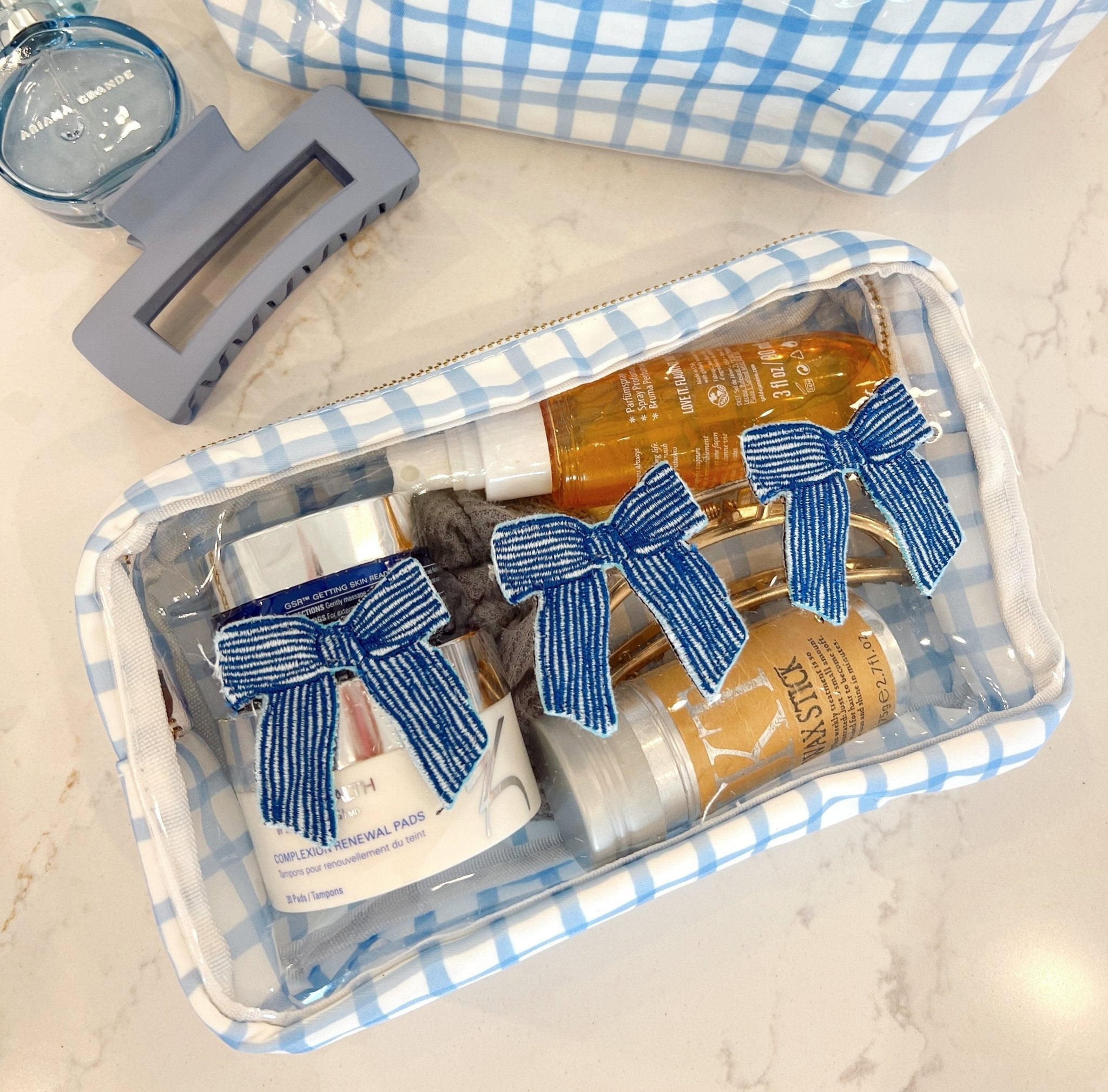Blue gingham makeup bag with three personalized items featuring blue striped bow designs inside clear packaging.