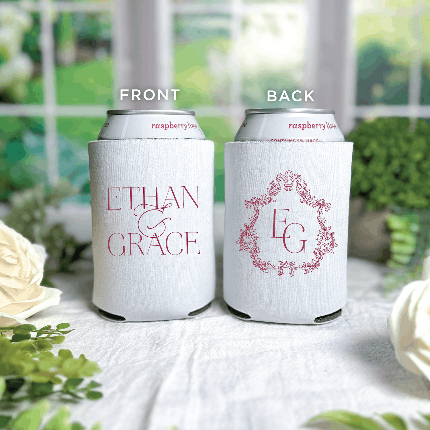 White can coolers with pink "Ethan & Grace" names and ornate crest monogram design, shown front and back views on garden table.