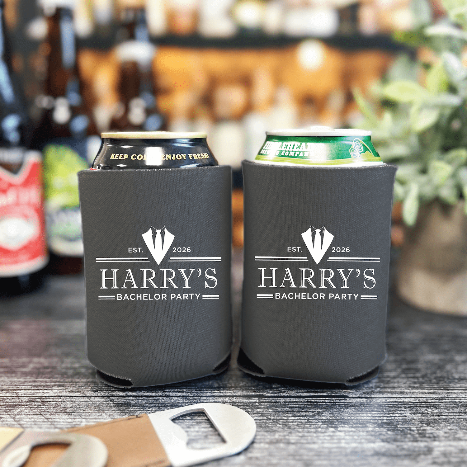 Black neoprene can coolers with "Harry's Bachelor Party" and date printed in white, holding beer cans