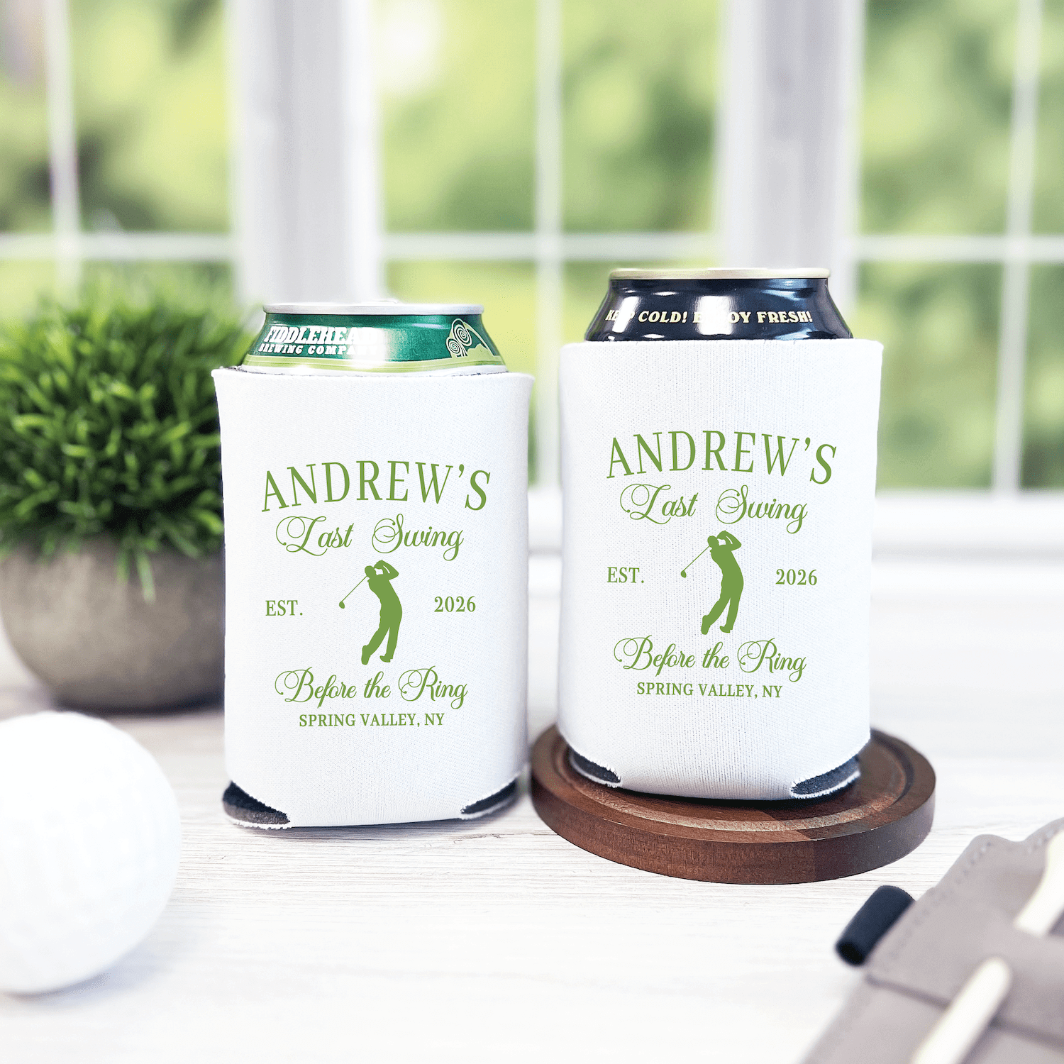 White can coolers with "Andrew's Last Swing Before The Ring" text and golf graphic, personalized with EST. 2026 and location details.