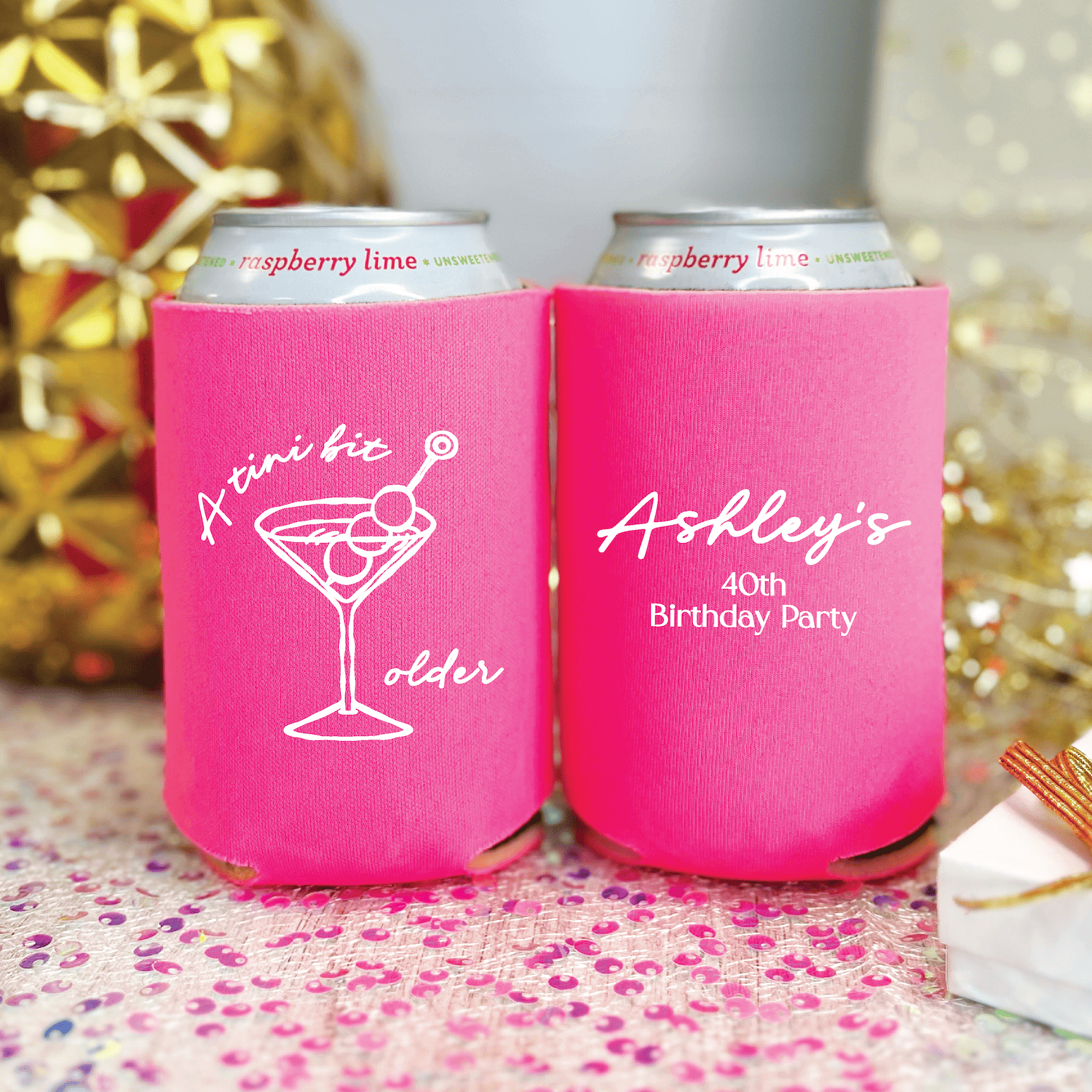 Bright pink can coolers with white martini glass and personalized text reading "A toast for colder" and "Ashley's 40th Birthday Party"