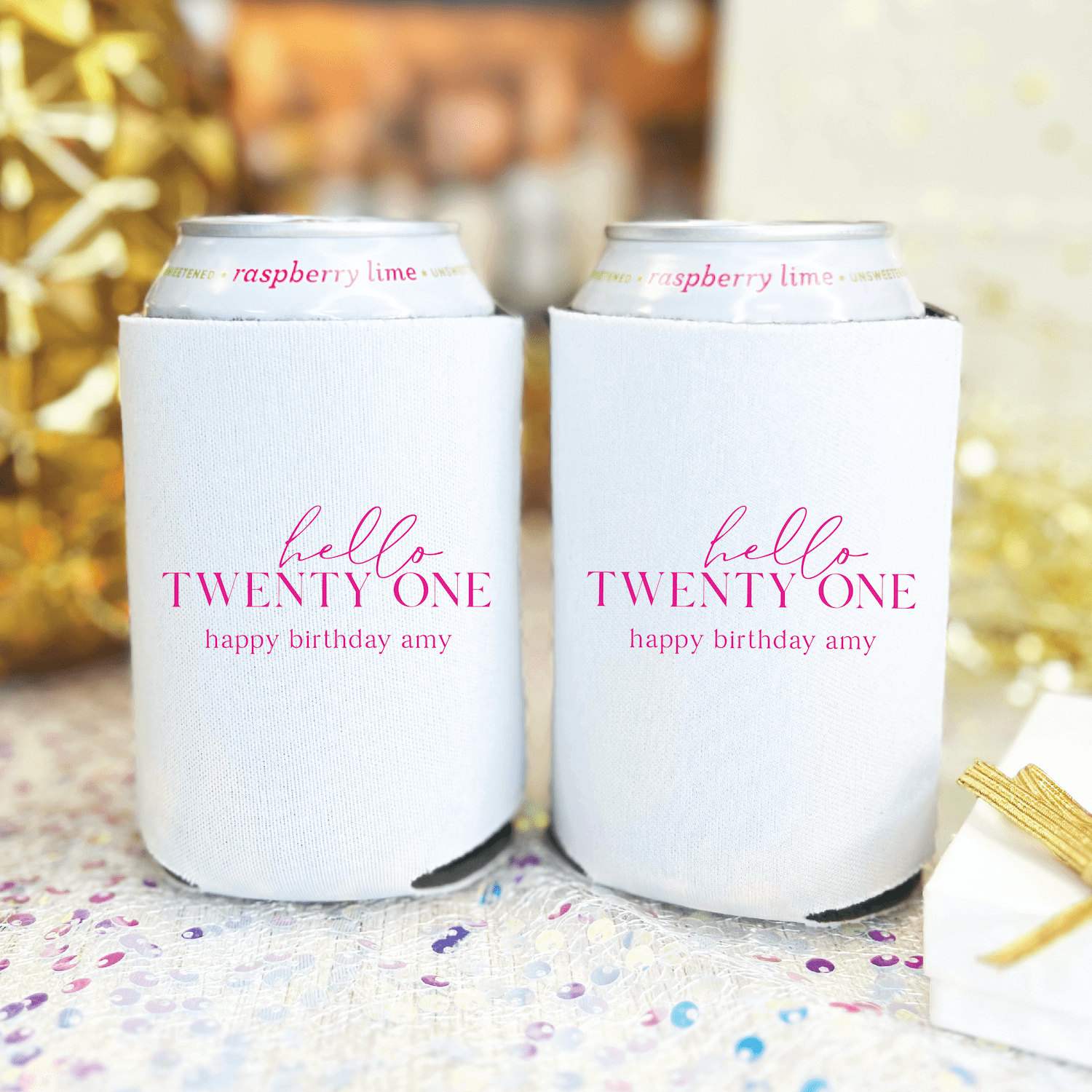 Two white can coolers with pink "hello twenty one happy birthday amy" personalized text design