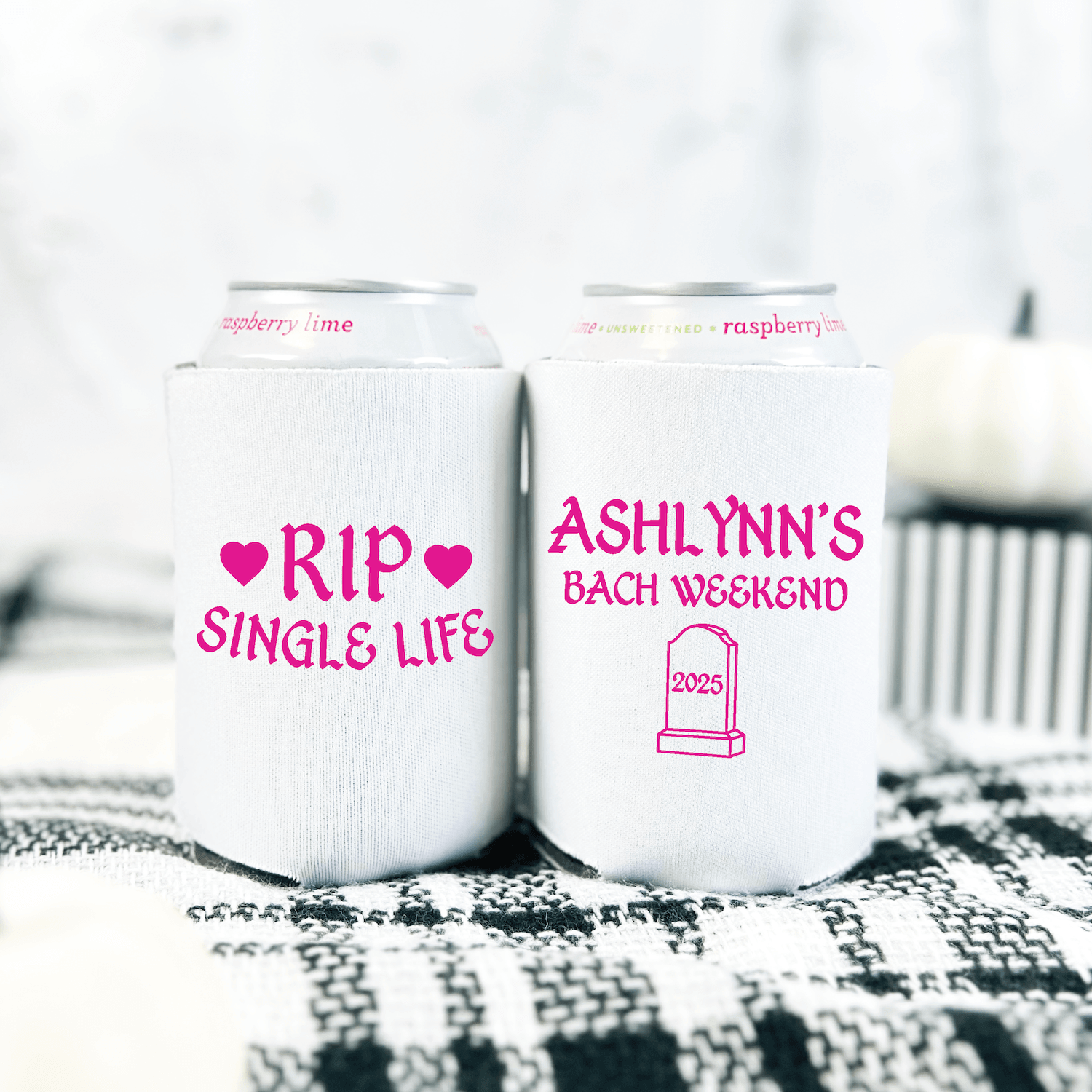 Two white can coolers with pink text, one reading "RIP SINGLE LIFE" with hearts, the other "ASHLYNN'S BACH WEEKEND" with a tombstone graphic.