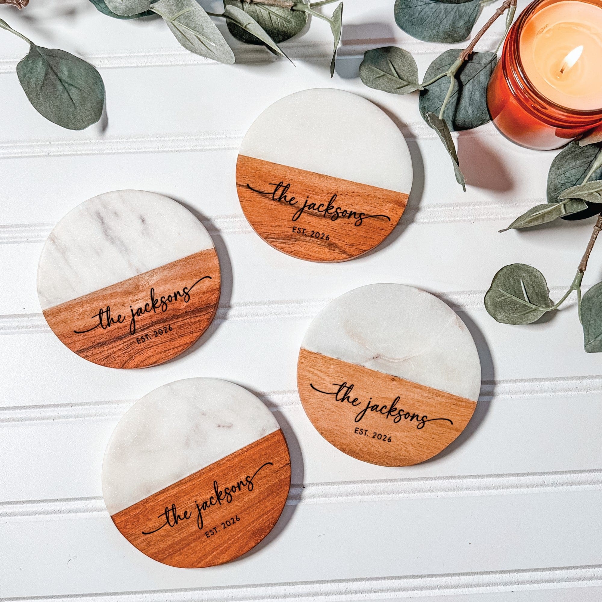 A set of four round drink coasters featuring a diagonal design of white marble and natural wood, ideal for wedding decor or a personalized gift.