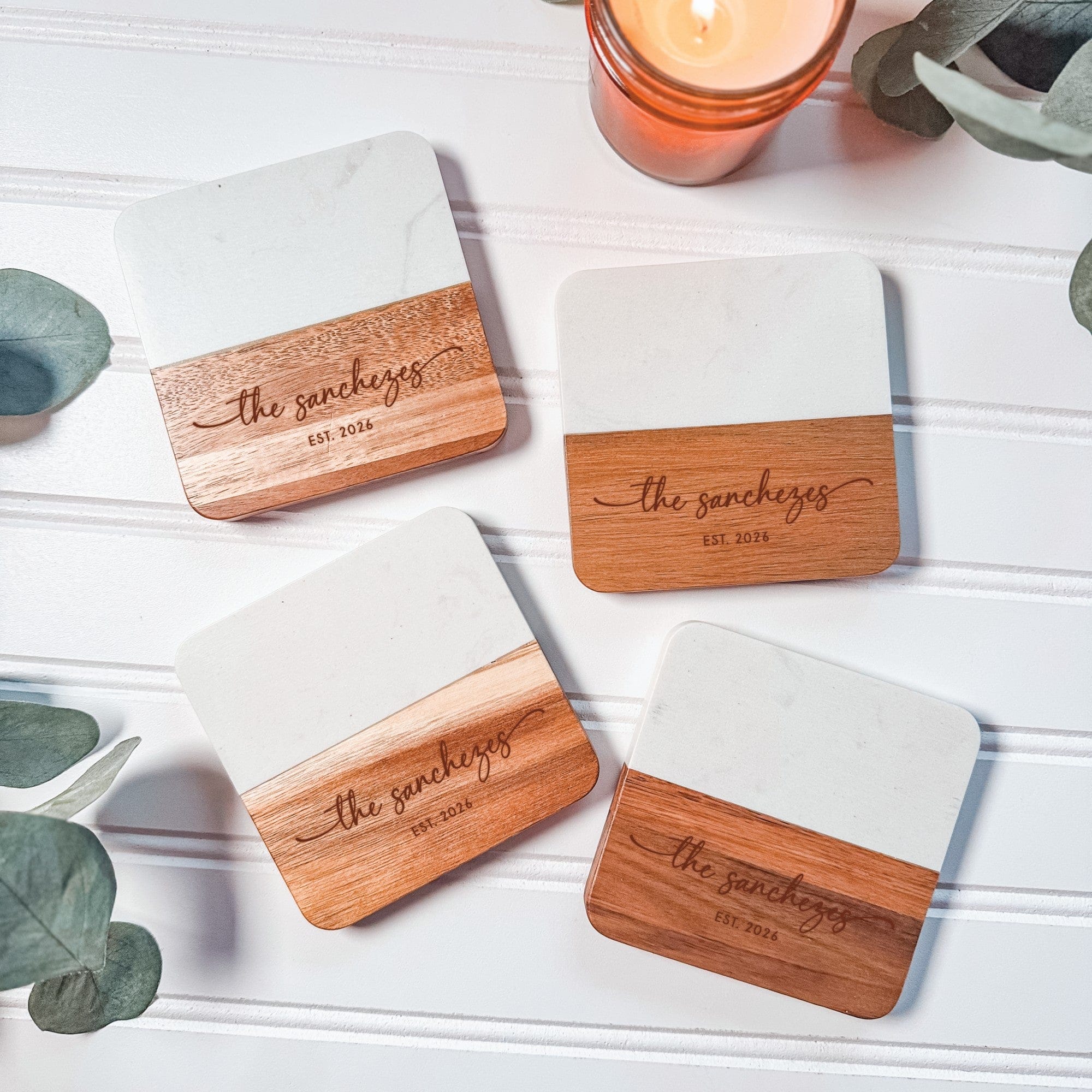 Four elegant wedding coasters featuring a white marble-look top and a light brown wooden base, ideal for event decor.