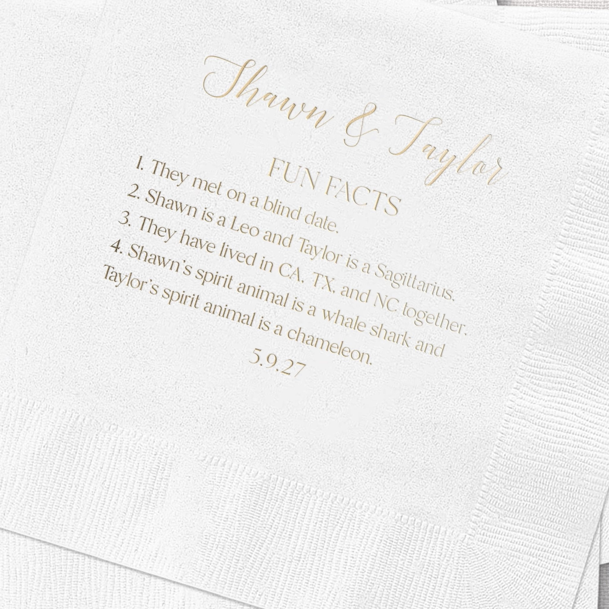 White napkin with gold foil text reading "Shawn & Taylor FUN FACTS" and numbered fun facts about the couple, dated 5.9.25