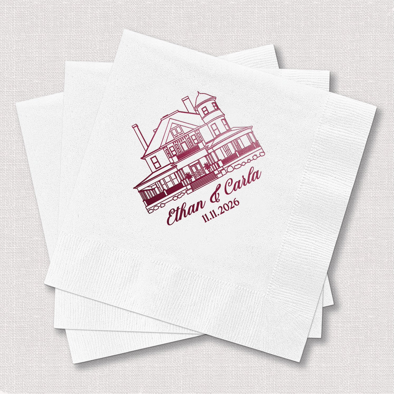 Stack of personalized white cocktail napkins with venue sketch wedding design printed with couple's names and venue illustration
